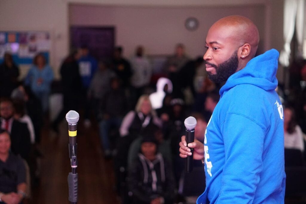 Photo of Darryl at a BRL showcase getting ready to introduce students up on stage